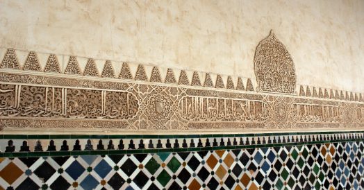 Paredes com friso em árabe entre azulejos e arabescos