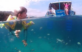 Criança e Peixes na Lagoa Azul