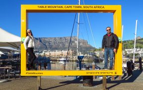 Casal na placa com a Table Mountain ao fundo