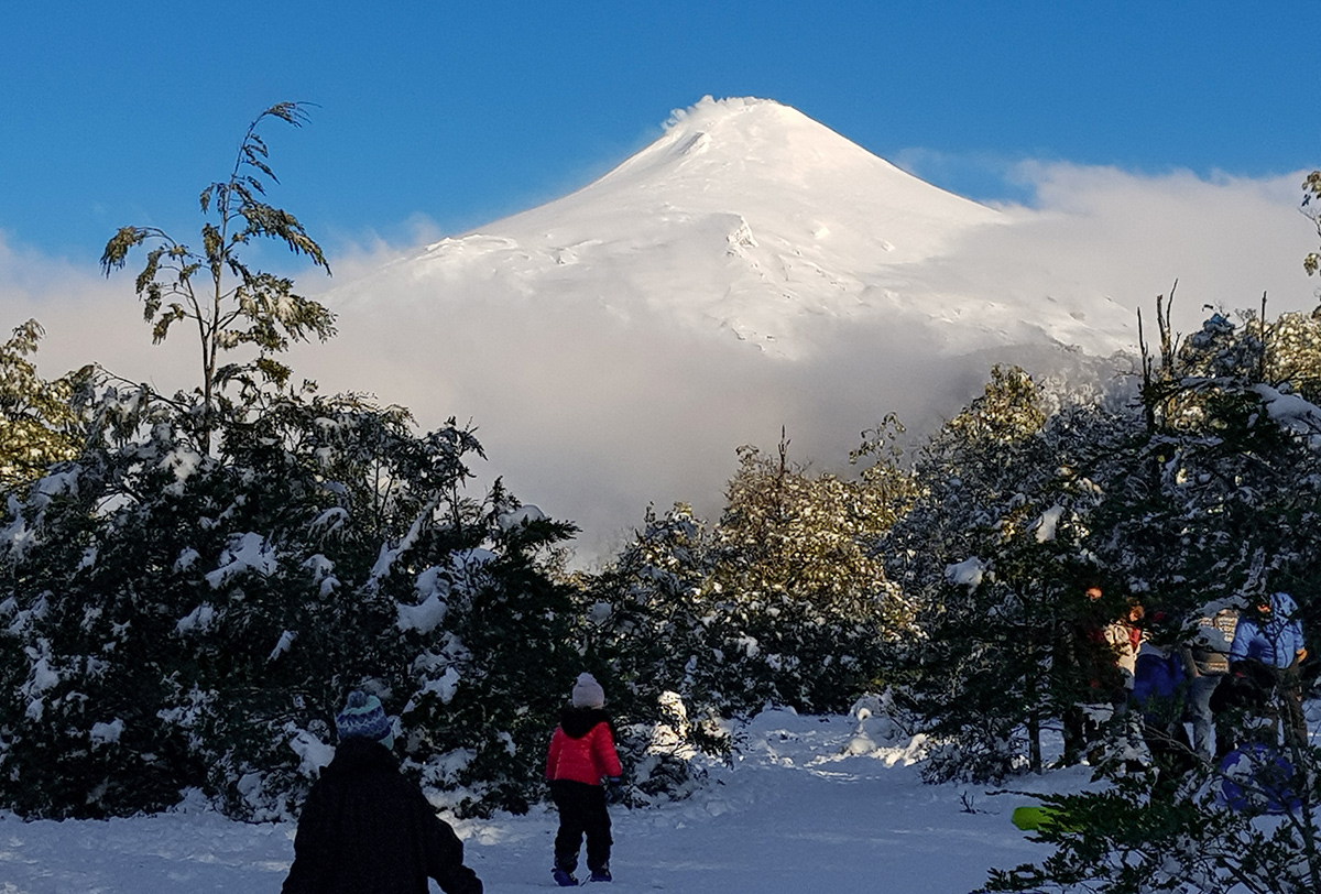 Crianças brincando na neve do vulcão Villarrica