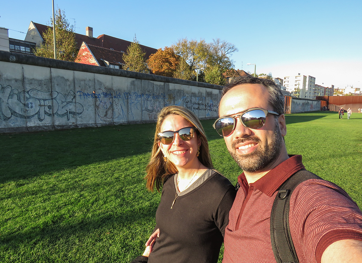 Casal ao lado do Muro de Berlim