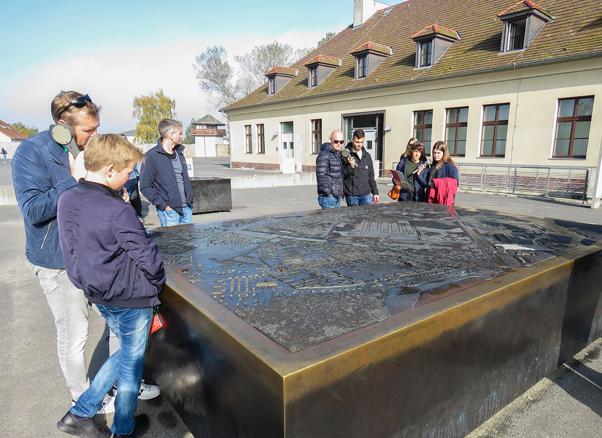 Turistas vendo o mapa de Sachsenhausen ao lado do Centro de Visitantes